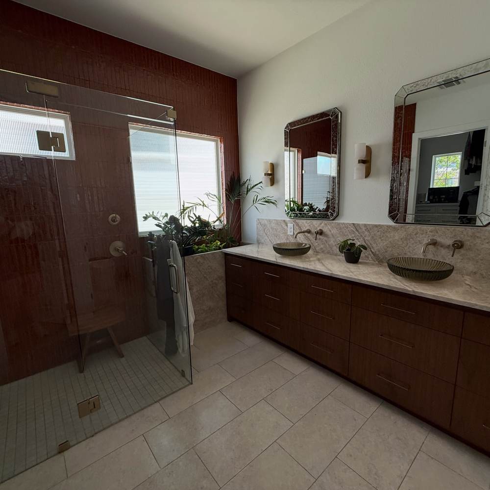 Polished bathroom with glass shower and double vanity